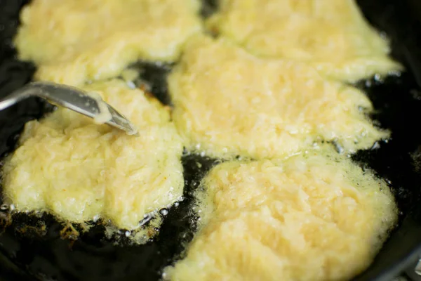 Le processus de friture des crêpes de pommes de terre dans une poêle . — Photo