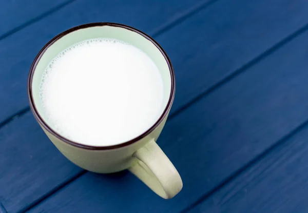 Большая чашка молока на синем фоне . — стоковое фото