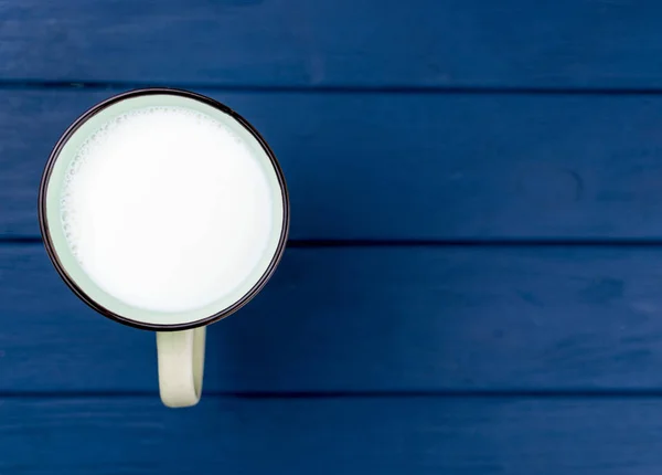 En stor kopp mjölk på en blå bakgrund. — Stockfoto