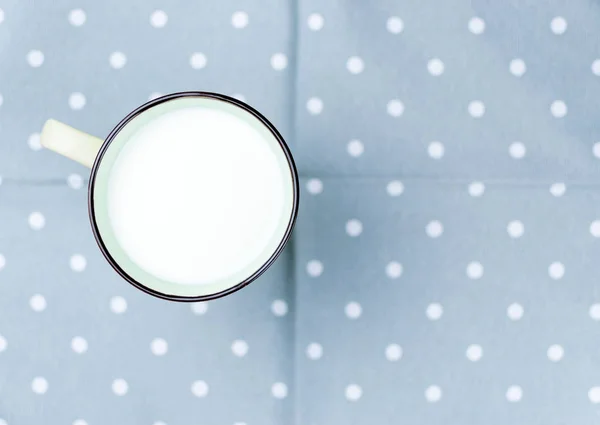 A large cup of milk on the tablecloth. — Stock Photo, Image