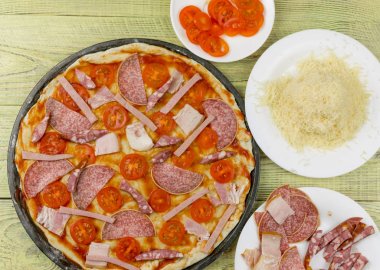 Taze çiğ İtalyan pizza pişirme sırasında. Pizza için malzemeler.