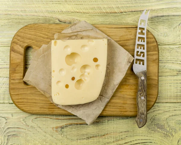 Peynir kesme tahtası ve ahşap arka plan üzerinde bıçak — Stok fotoğraf