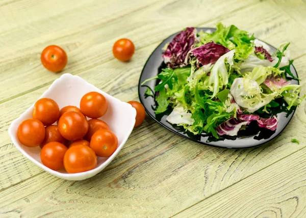 Salada vegetariana de legumes frescos e tomate prato de cereja em um fundo de madeira . — Fotografia de Stock