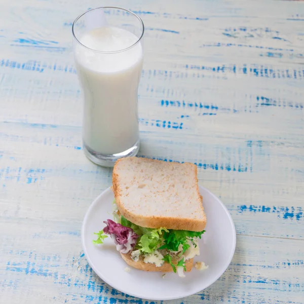 Vegetarian sandwich with salad and cheese and a glass of yoghurt (yogurt) on a wooden background. Proper healthy eating. — Stock Photo, Image