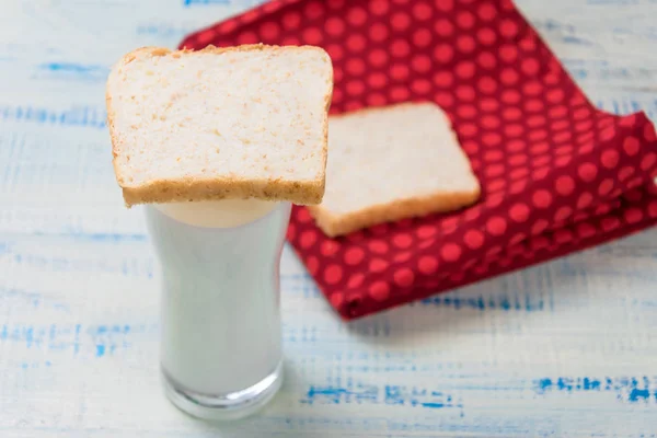 Kefir, yoghurt i ett glas på en bakgrund av skivor av vitt bröd på en trä bakgrund. — Stockfoto