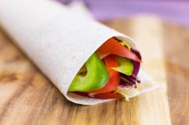 Tahta arka planda bir rulo Pita ekmeği ve taze sebze hazırlamak. Sağlıklı beslenme kavramı.