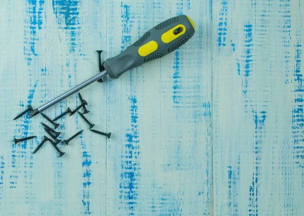 Schrauben und Schraubenzieher auf einem hölzernen Hintergrund. das Konzept der Reparatur. — Stockfoto