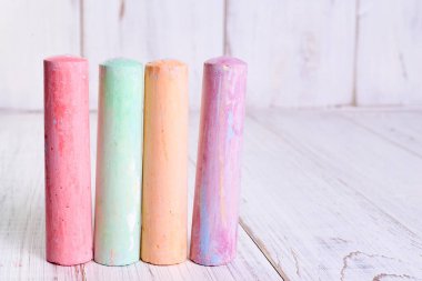 Açık ahşap zemin üzerine çizim yapmak için çok renkli tebeşir. Çocukların yaratıcılığı kavramı..