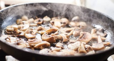 Tavada kızarmış mantar. İçinden buhar çıkan mantarlar..