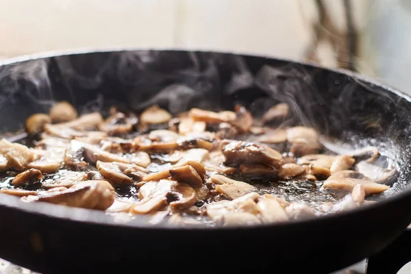 Fried mushrooms in a pan. Cooking mushrooms with steam emanating from them.