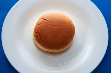 Mavi arka planda hamburger ekmeği.