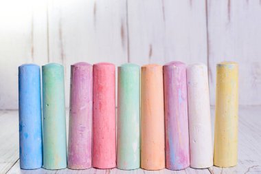 Açık ahşap zemin üzerine çizim yapmak için çok renkli tebeşir. Çocukların yaratıcılığı kavramı..