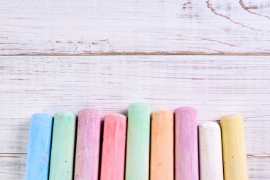 Açık ahşap zemin üzerine çizim yapmak için çok renkli tebeşir. Çocukların yaratıcılığı kavramı..