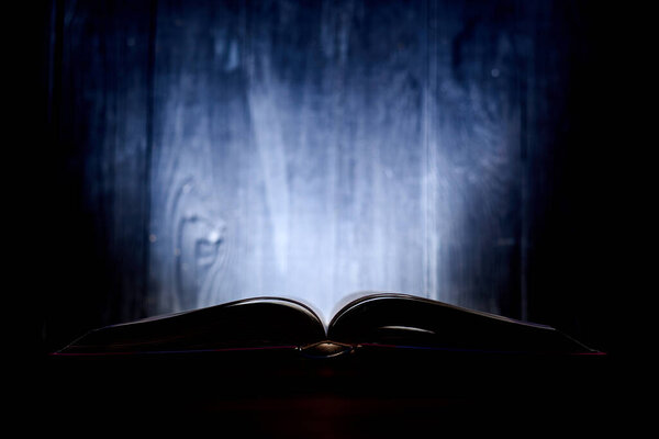An open book with a glow in the background.
