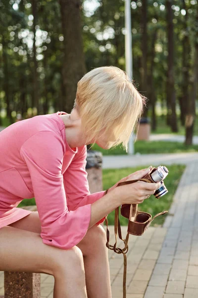 Žena Červených Šatech Retro Kamerou Sedí Lavičce Letním Parku — Stock fotografie