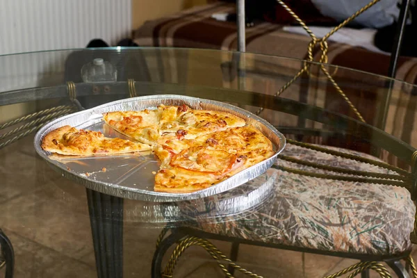 Pizzastücke liegen auf dem Glastisch. — Stockfoto