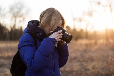 Bir kadın fotoğrafçı elinde bir kamera tutuyor. Kadın foto muhabiri kavramı.