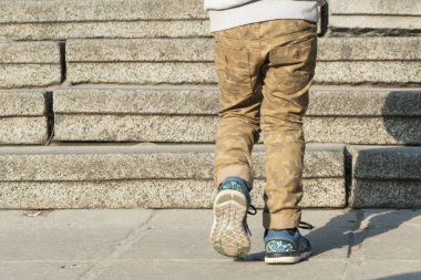 Merdivenlerden çıkan küçük bir çocuğun bacakları..