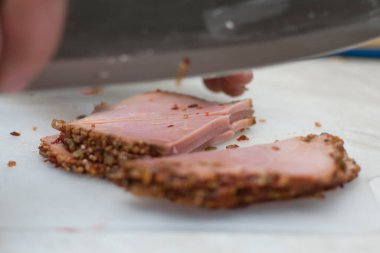 Erkek eli jambon kesiyor, eti kesme tahtasında hazırlıyor..