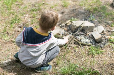 Küçük bir çocuk ateş yakıyor..