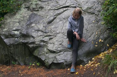 Genç bir kız, büyük bir taşın arkasında depresyona girmiş..