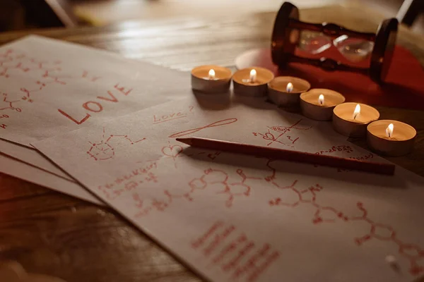 配方爱情的概念 寻找答案的问题 什么是爱 烛光照射下含有激素化学配方的纸片 — 图库照片
