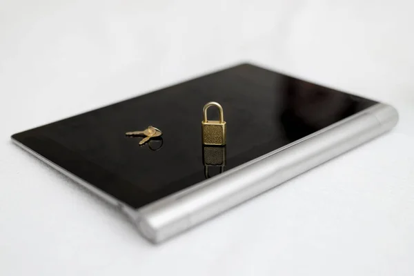 Electronic security and data protection concept. Tablet computer and lock with keys.