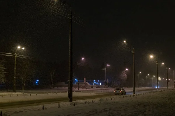 Street in the snow at night.