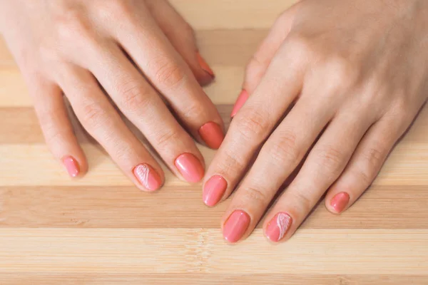 Mãos Femininas Com Uma Manicura Fundo Madeira — Fotografia de Stock