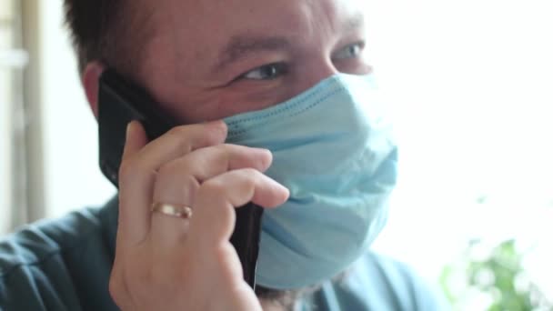 Een Man Met Een Medisch Masker Die Telefoneert — Stockvideo