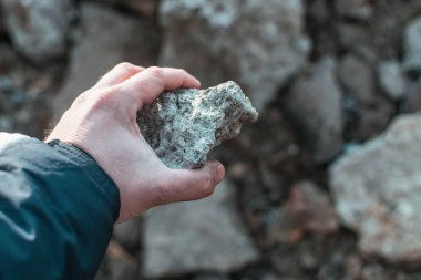 Taşı tutan bir erkek..