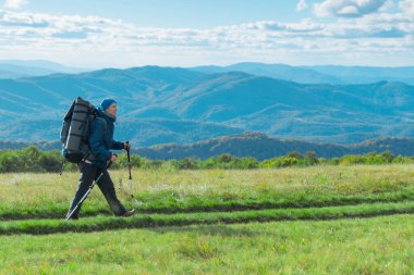 Sırt çantalı bir kadın dağda yürüyüşe çıkmış..