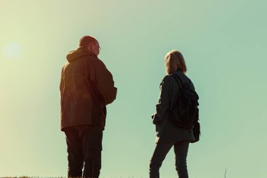 Gökyüzünün karşısında bir adam ve bir kadının silueti. Çift olarak ilişki kavramı.
