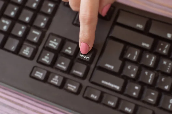 Woman presses the delete key.