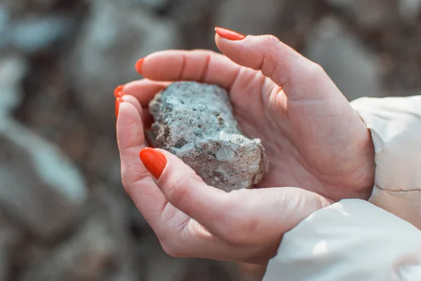 Dişi eller bir taşı tutar.
