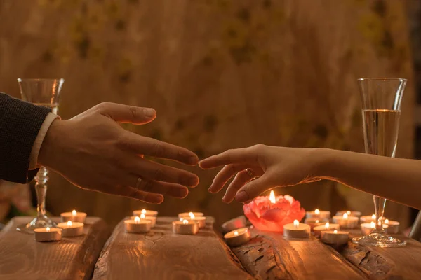 一个男人和一个女人在一个浪漫的晚餐 一男一女的手在烛光下相互牵手 — 图库照片