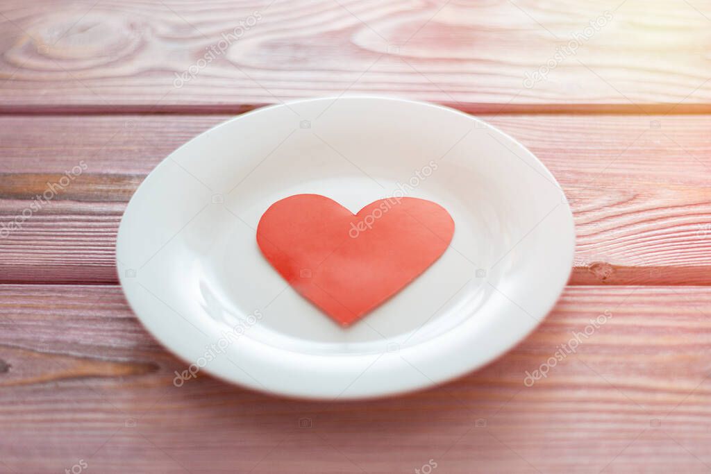 Love heart on a plate. The concept of nutrition love, heartwarming, losing weight because of love.