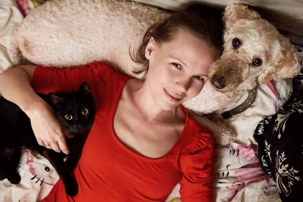 Een Vrouw Ligt Een Bank Met Een Kat Een Hond — Stockfoto