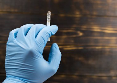 Esmer arka planda lastik eldivenle sigara içmek..