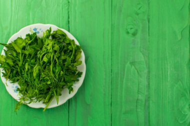 Açık yeşil ahşap bir zeminde taze yeşiller.