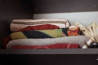 Katlanmış şeylerle dolu raf dolabı. Dolabın düzenini koruyun..