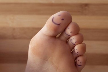 Boyalı gülüşlü kadın ayak parmakları.