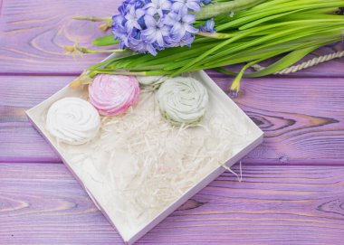 Marshmallow (zephyr) bir hediye kutusunda ahşap bir arka planda. Tatlı hediye..