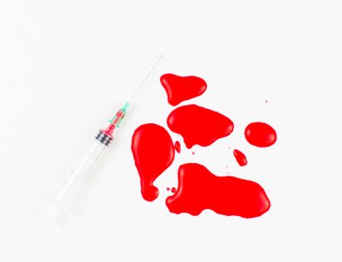 Beyaz arka planda şırınga ve kan gölü