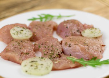 Ahşap zemine baharat serpiştirilmiş çiğ tavuk filetosu. Yemek hazırlığı.