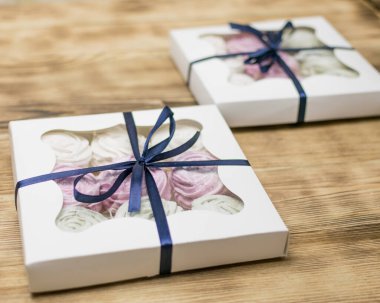 Tahta bir arka planda hediye kutusunda marşmelov. Tatlı hediye..