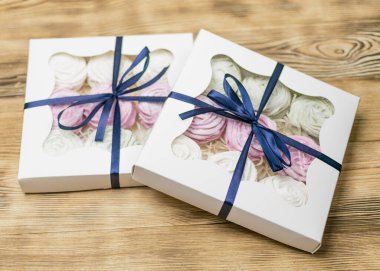 Tahta bir arka planda hediye kutusunda marşmelov. Tatlı hediye..