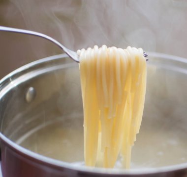 Tavanın arkasındaki çataldan sarkan haşlanmış spagetti. Spagettiden buhar çıkıyor..