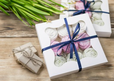 Tahta bir arka planda hediye kutusunda marşmelov. Tatlı hediye..