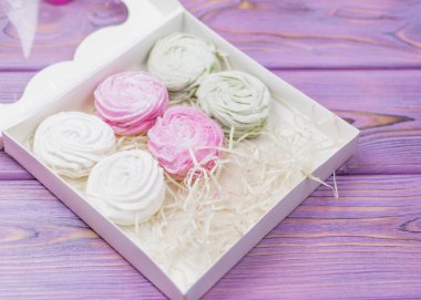 Marshmallow (zephyr) bir hediye kutusunda ahşap bir arka planda. Tatlı hediye..